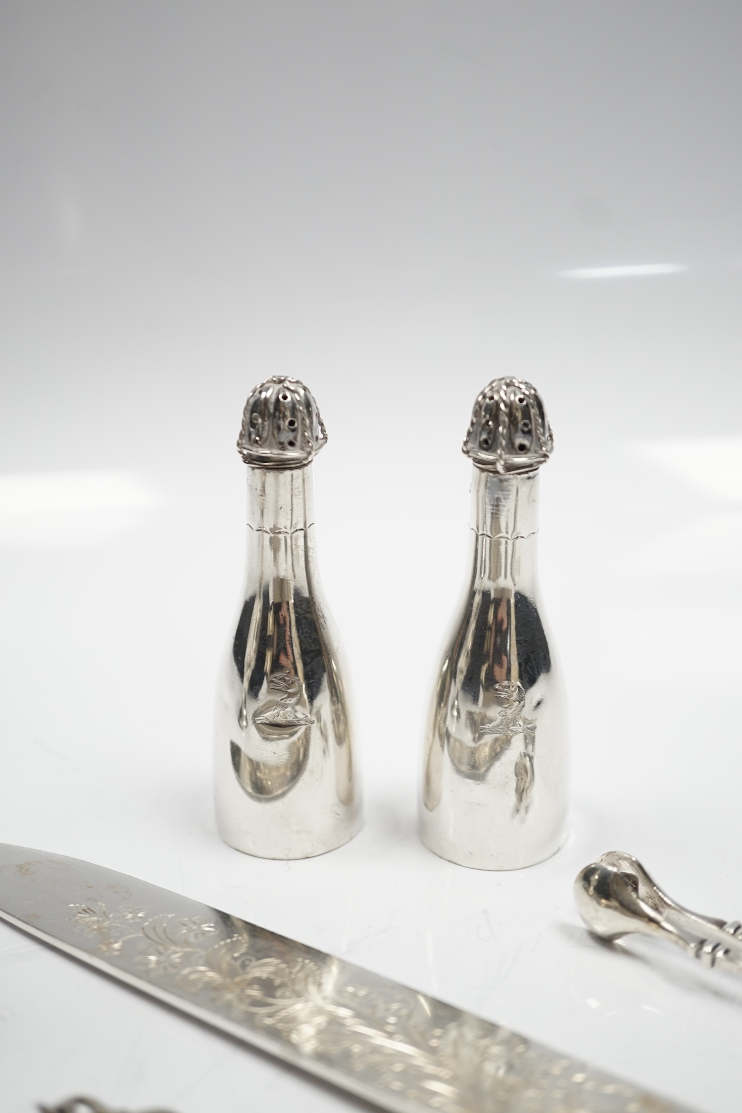 A George III silver inverted pear shaped cream jug, with later embossed decoration, London, 1774, a pair of late Victorian bottle shaped pepperettes and other small silver.